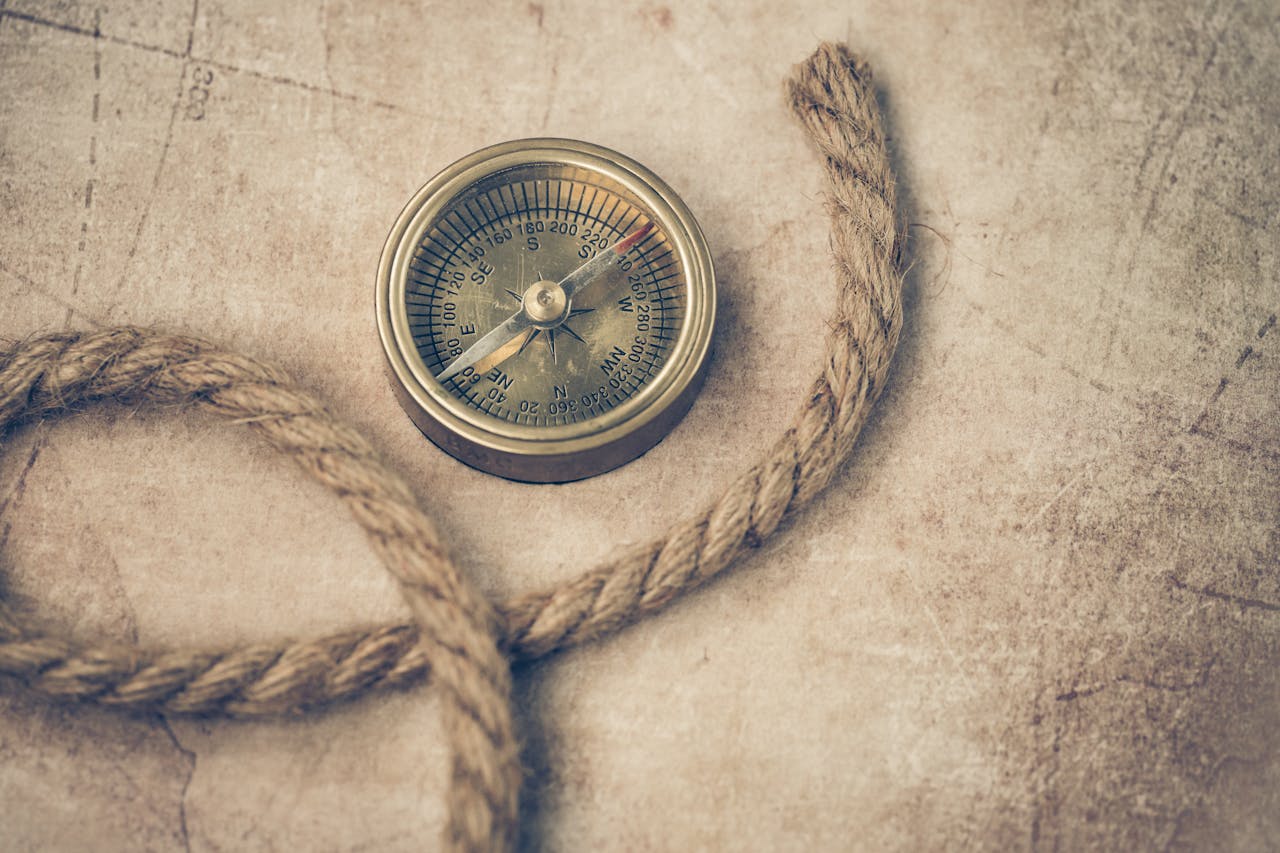 An old compass and rope resting on a vintage map, evoking adventure and navigation.